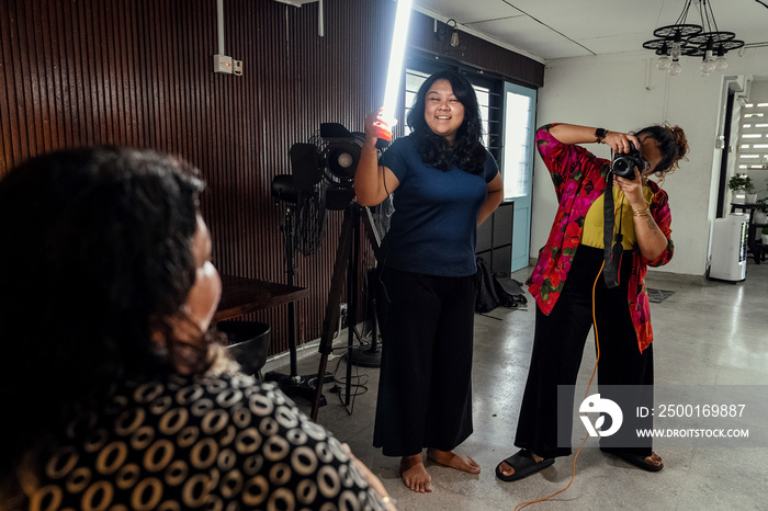 Plus sized female getting her headshots taken by a south asian female photographer