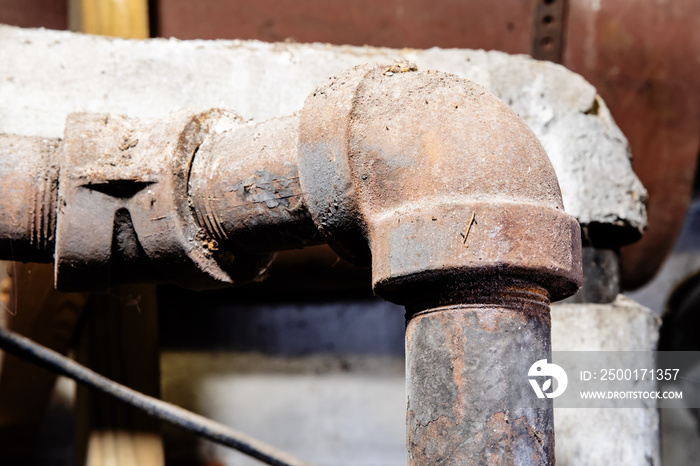 dangerous broken asbestos wrap insulation on rusty heating system pipes