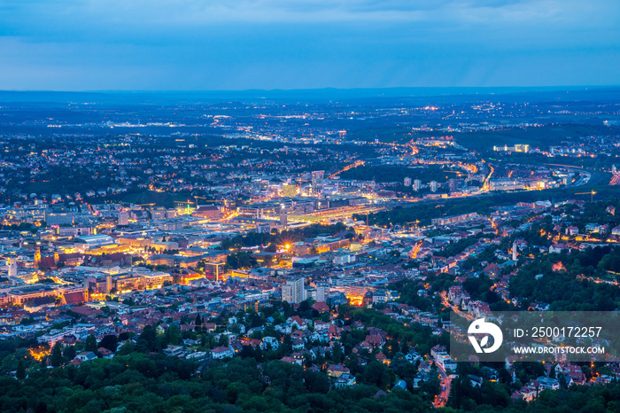 Germany, Magical illuminated lights of stuttgart city houses, buildings, streets and cranes by night from above aerial perspective