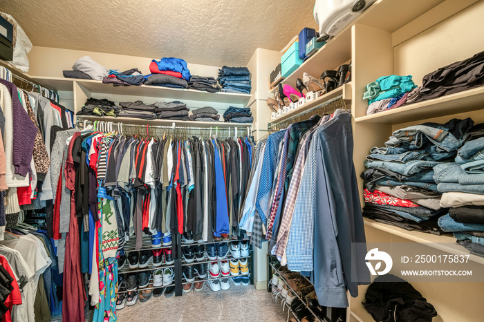 Small walk in closet with hanging rods and shelves