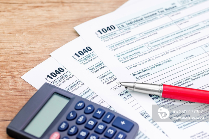 1040 tax form with calculator and pen