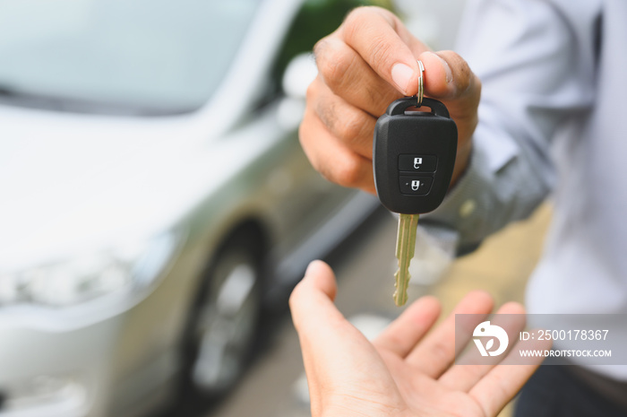 Businessman giving a car key. Getting new car concept.