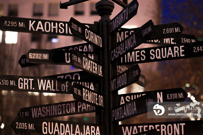 Signpost. Directional marker to world landmarks at night in dowtown.