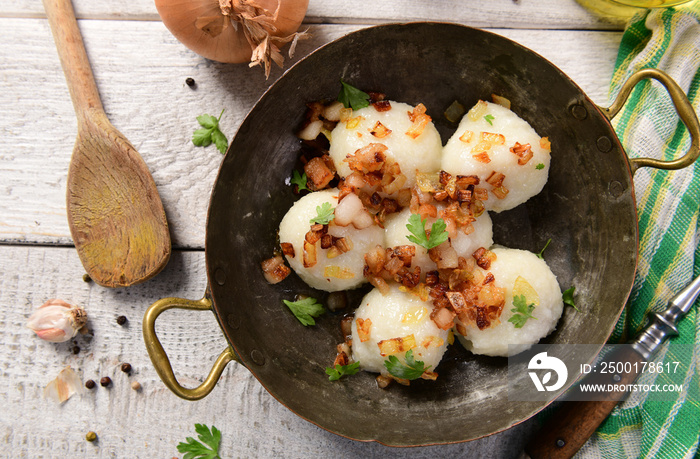 Meat stuffed potato dumplings with fried onion  and greaves on top