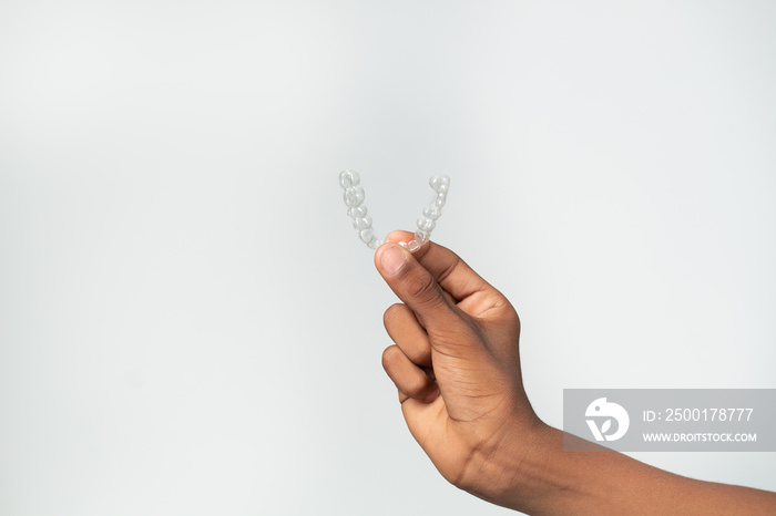 hand of boy teenager with dental aligners isolated