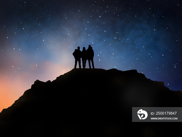 travel, hike and success concept - group of travelers or friends standing on edge of mountain over starry night sky or space background