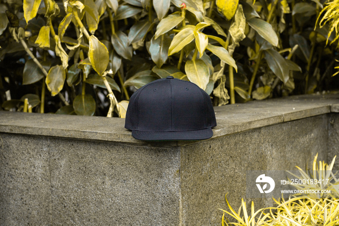 Black snapback hat cap flat visor in outdoor.