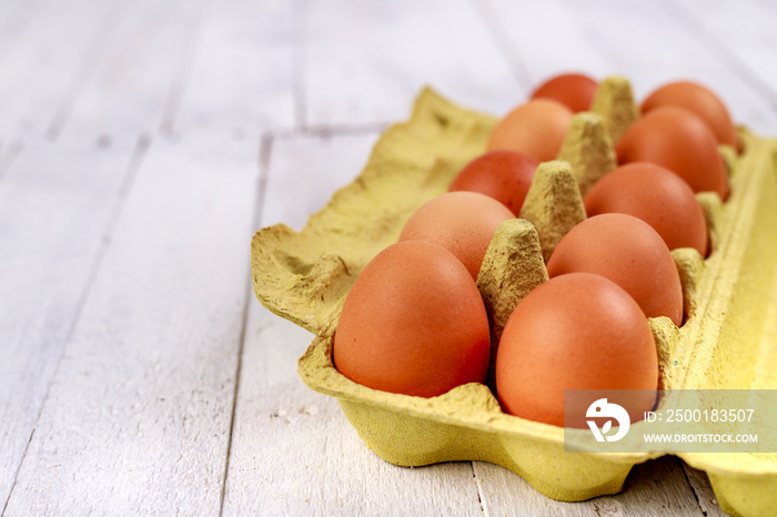 Fresh eggs in a cardboard form on a wooden table. Tasty eggs for baking bread in the bakery.