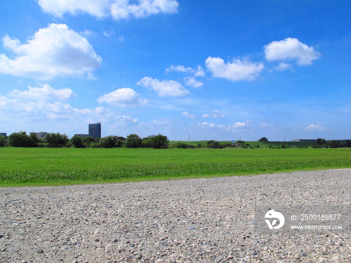 秋の江戸川河川敷の砂利道とサッカー場風景