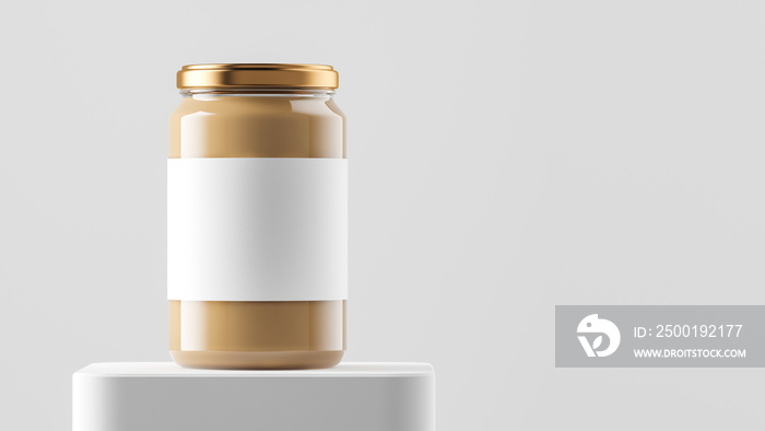 Big tall transparent glass jar with copper metal cap and blank label filled by nut butter on the podium over white background.