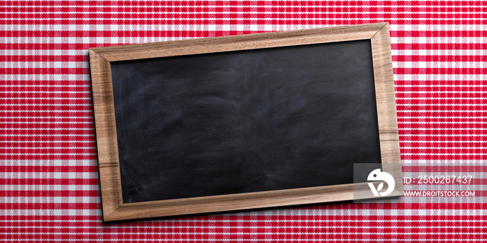 红色格纹野餐桌布上的黑板，文本空间。3d插图