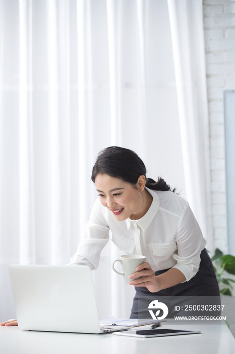 青年商务女人使用笔记本电脑办公