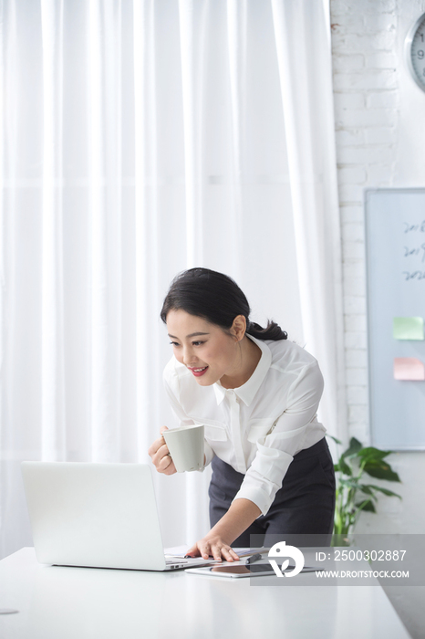 青年商务女人使用笔记本电脑办公