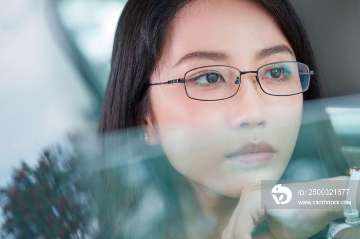 青年女人坐在汽车里向外看