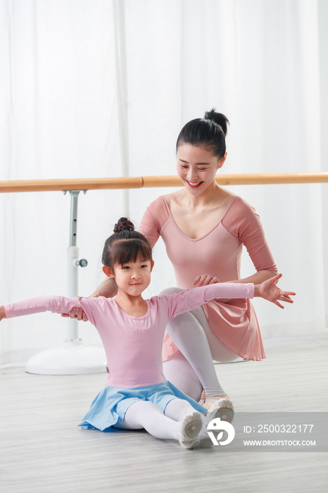 年轻舞蹈老师教小女孩跳舞