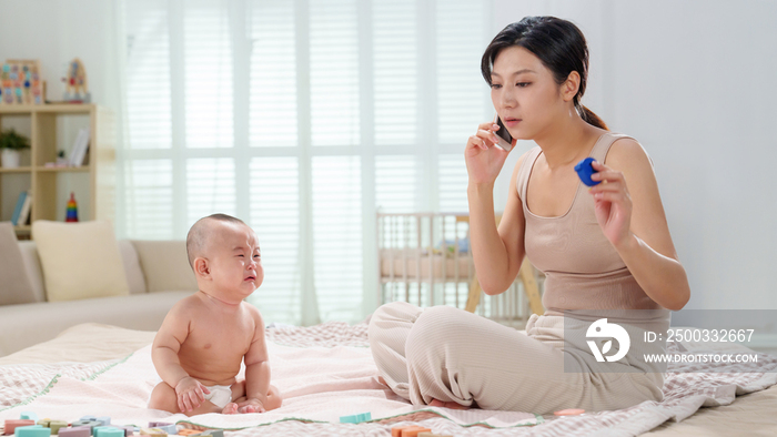 陪伴宝宝的年轻妈妈打电话