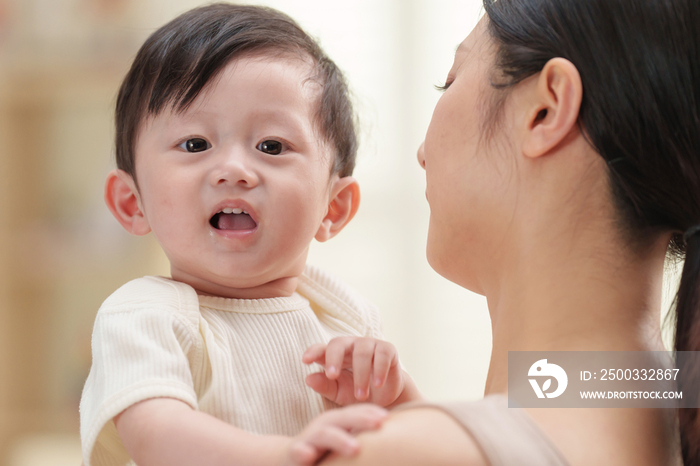 年轻妈妈抱着可爱的宝宝