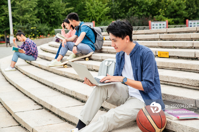 热爱学习的大学生坐在台阶上学习