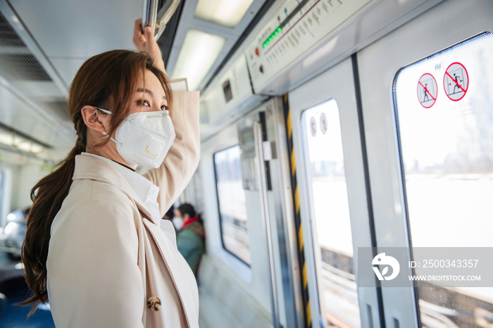 戴口罩的年轻女人乘坐地铁