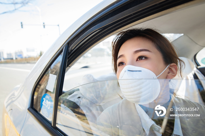 年轻女人戴口罩乘坐汽车