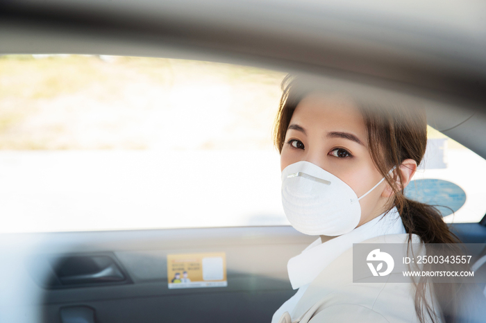 年轻女人戴口罩乘坐汽车