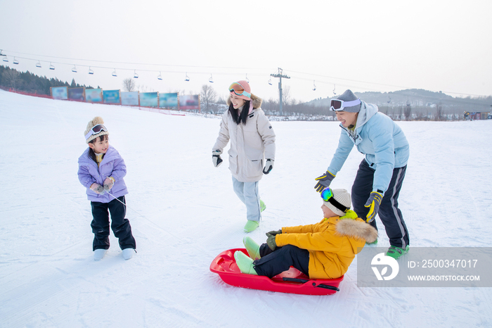 玩雪上滑板幸福的一家四口