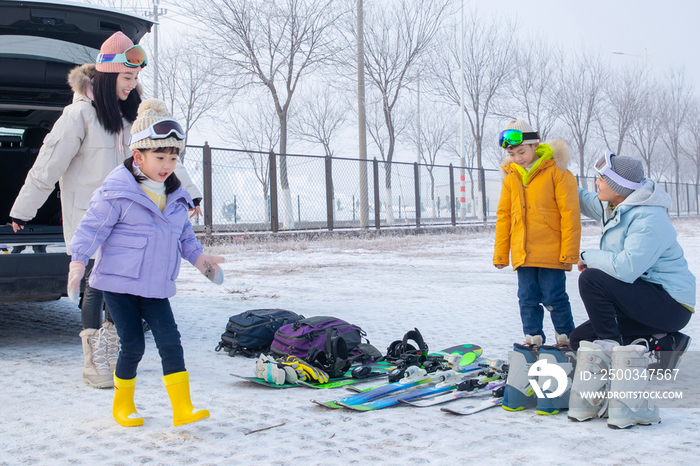 停车场内清点滑雪装备的一家四口