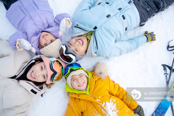 幸福的一家四口躺在雪地上