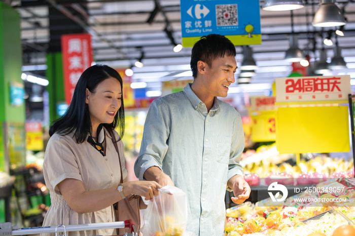 中年夫妇在超市挑选水果