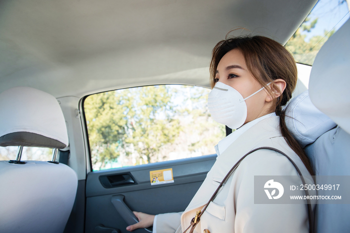 年轻女人戴口罩乘坐汽车