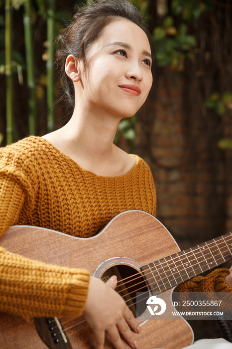 年轻女人弹吉他