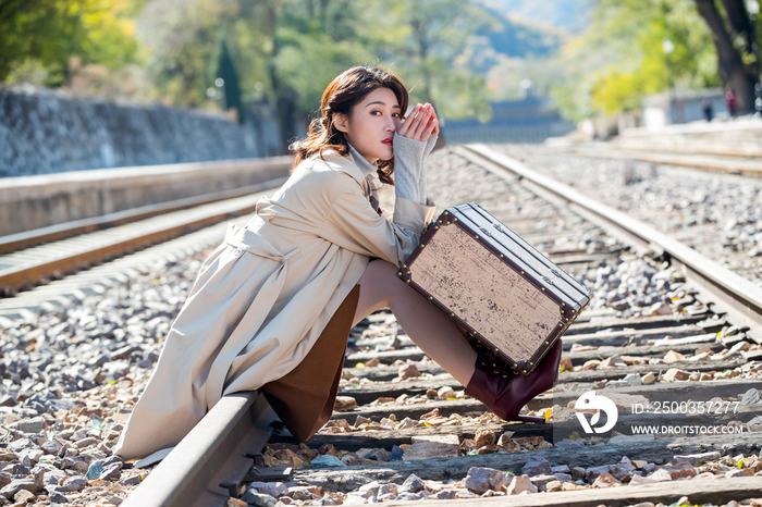 青年女人坐在铁轨上