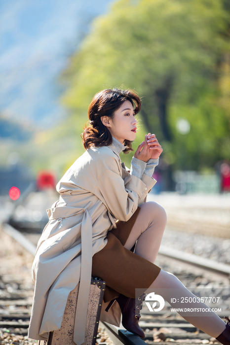 青年女人坐在铁轨上