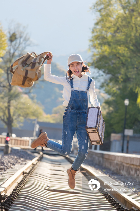 青年女人在铁轨上跳跃