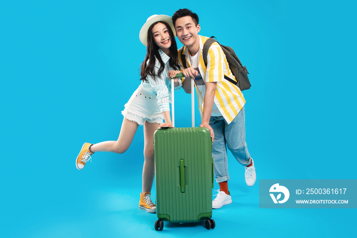 快乐的青年情侣一起推着行李箱去旅游