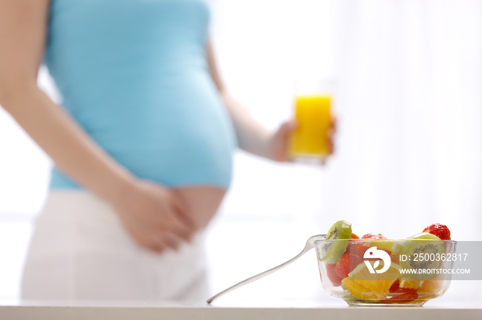 孕妇面前放着各种水果