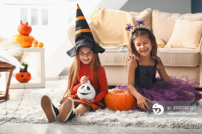 Cute little girls in Halloween costumes at home