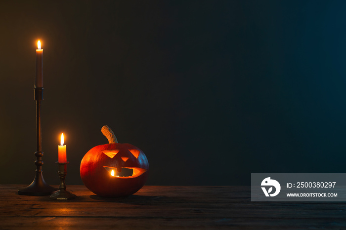 halloween pumpkins with burning candles on dark background