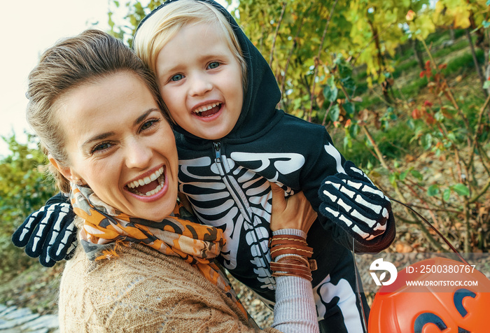 smiling modern mother and daughter on Halloween outdoors