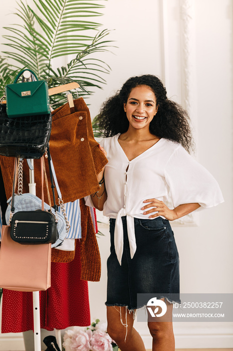 Fashion stylist posing at clothes rack