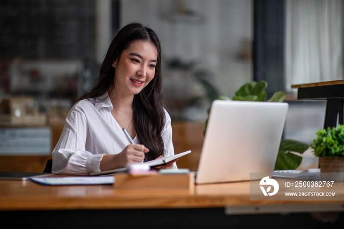 Shot of an Asian young business Female working on laptop computer in her workstation.Portrait of Bus