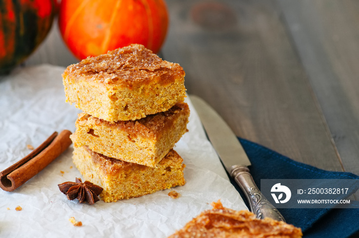 Pumpkin cornmeal bars with spices on a wooden background. Close up.