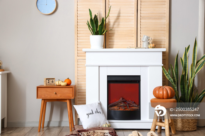 Interior of living room with autumn decor and fireplace