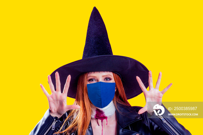 redhaired ginger woman wearing black leather jacket for halloween party ,studio yellow background.