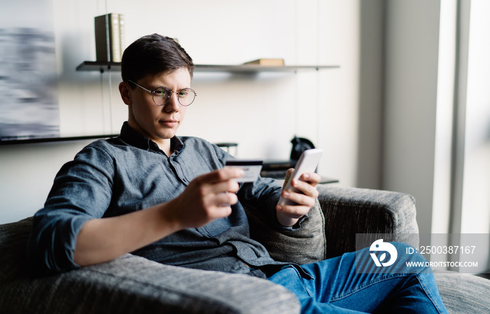 Man using smartphone and credit card for e payment transaction