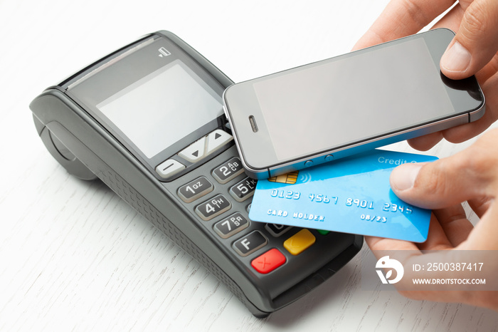 Contactless payment by credit card and smartphone phone. POS terminal NFC payment. Concept of how to