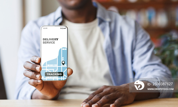 Black Man Demonstrating Smartphone With Opened Delivery Service Tracking App On Screen