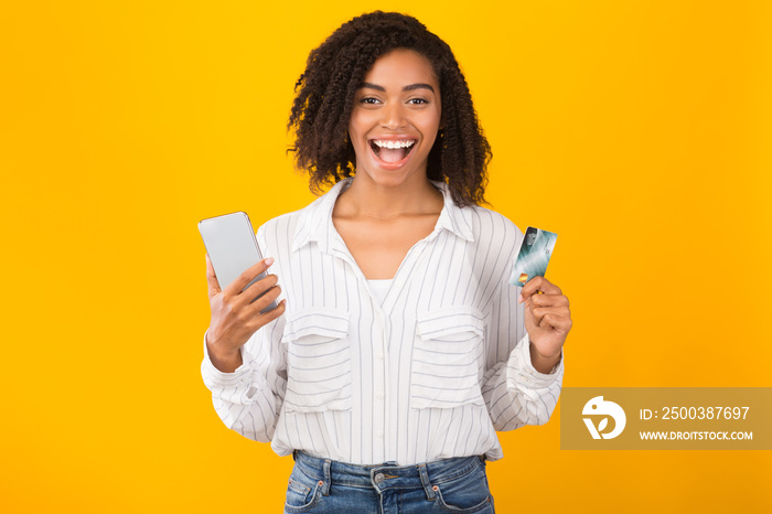 Black woman holding credit card and mobile phone