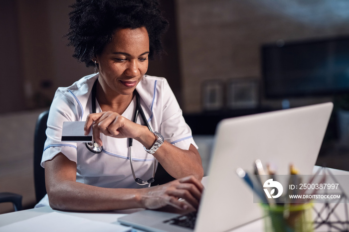 Smiling African American female nurse shopping online.