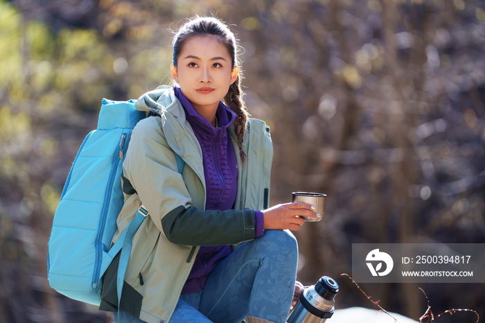 徒步旅行的青年女人坐着休息